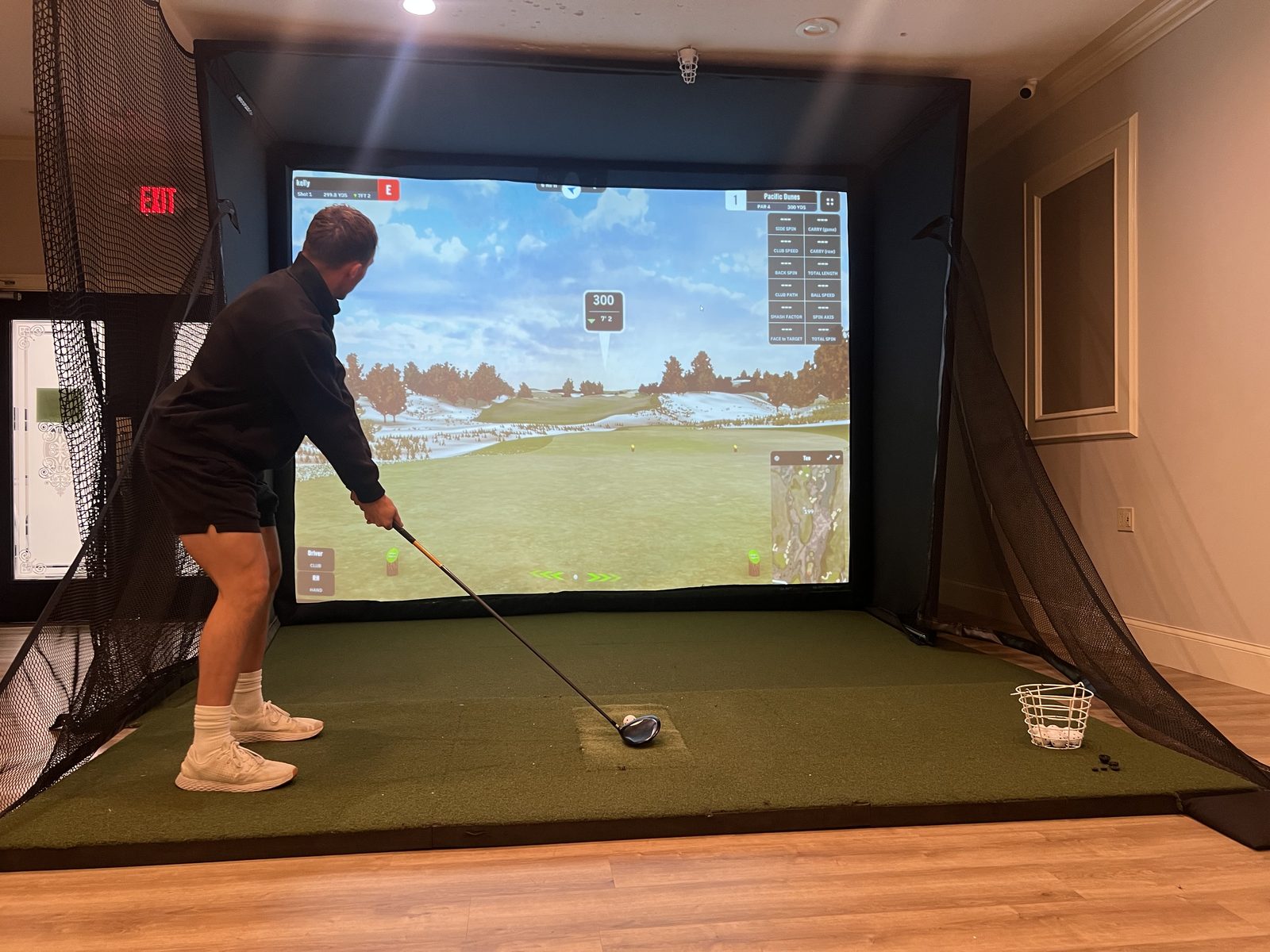 A golfer lining up a drive on the golf simulator at The Club