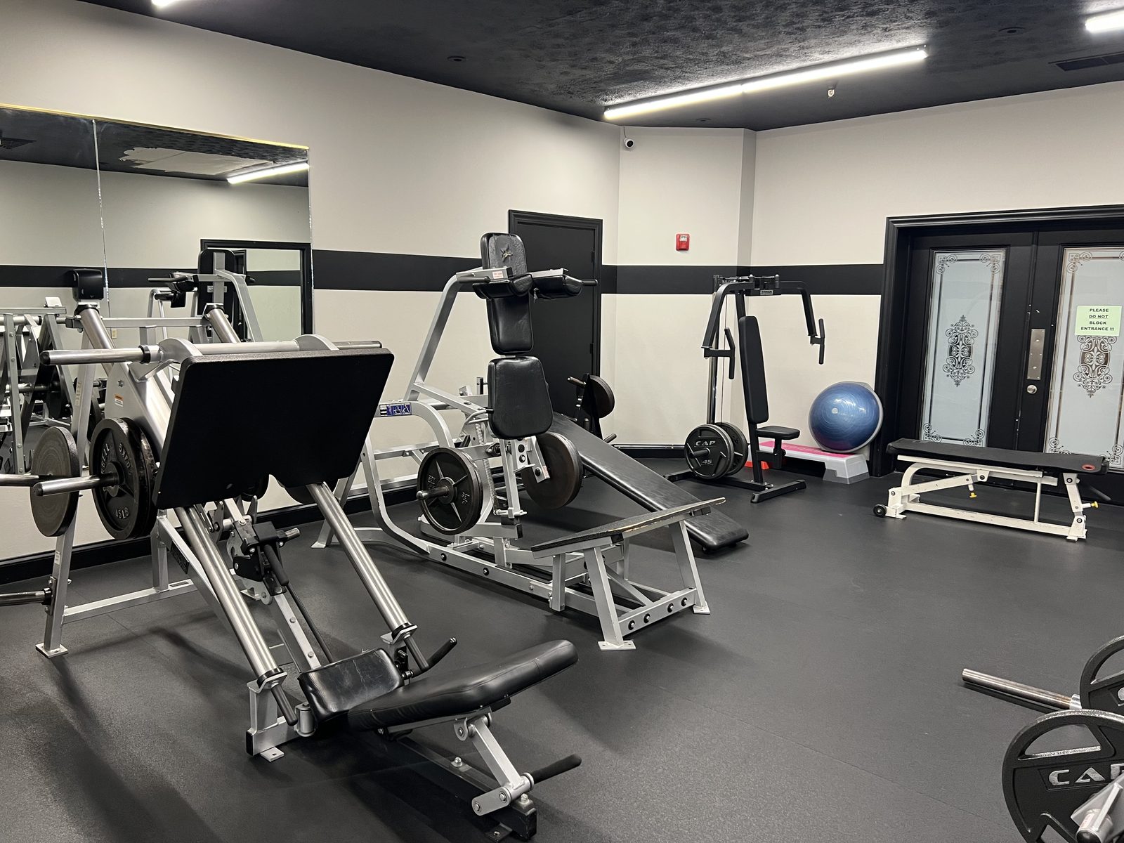 Plate-loaded strength machines at The Club — leg press, hack squat and pec deck